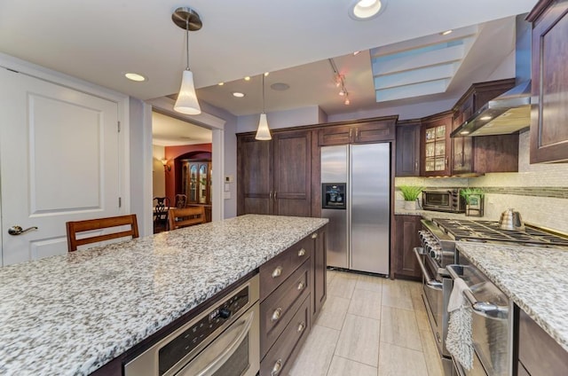 221 8th St, Downers Grove, IL 60515 - kitchen featuring appliances with stainless steel finishes, wall chimney exhaust hood, backsplash, hanging light fixtures, and light stone counters