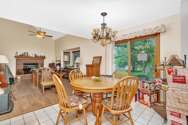 25056 Madison St, Plainfield, IL 60544 - dining area with a chandelier, ceiling fan, a brick fireplace, light tile patterned floors, and lofted ceiling