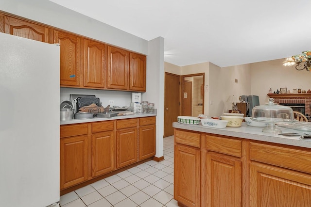 25056 Madison St, Plainfield, IL 60544 - kitchen with freestanding refrigerator, light countertops, light tile patterned floors, and brown cabinetry