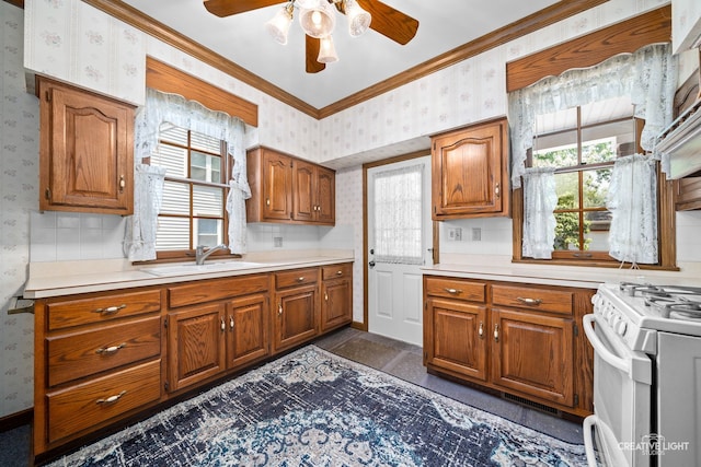 811 W Galena Blvd, Aurora, IL 60506 - kitchen with wallpapered walls, white range with gas stovetop, brown cabinetry, ceiling fan, and light countertops