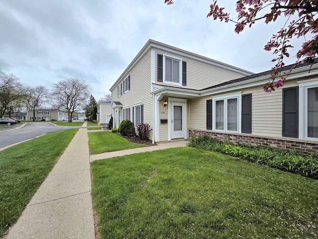 view of front of house with a front lawn and brick siding