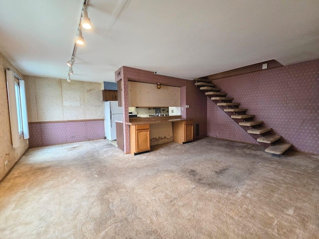 interior space with wainscoting, stairway, wallpapered walls, light colored carpet, and rail lighting