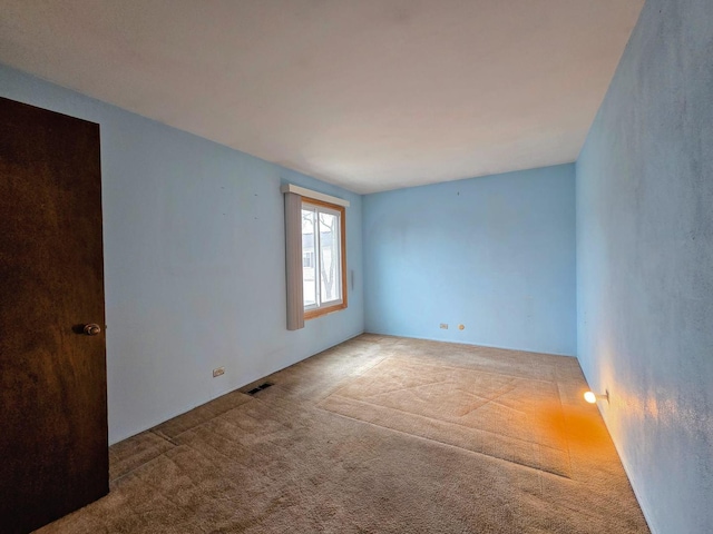 empty room featuring visible vents and carpet floors