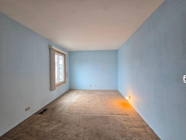 empty room featuring carpet floors and visible vents