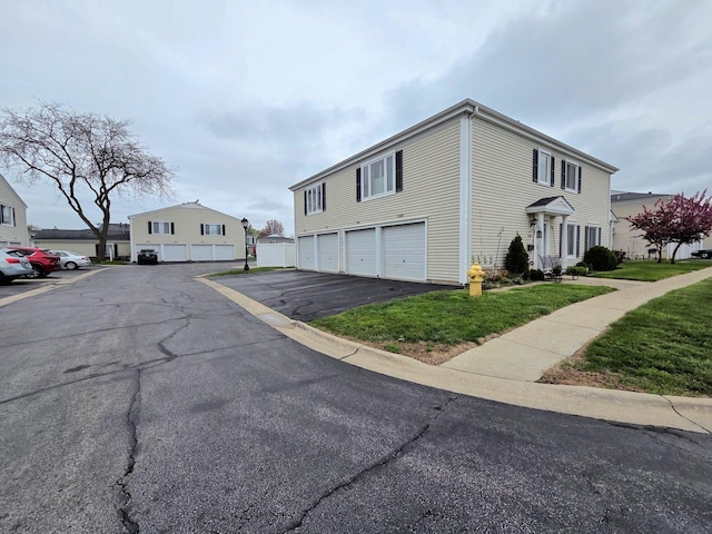view of side of home with a lawn and driveway