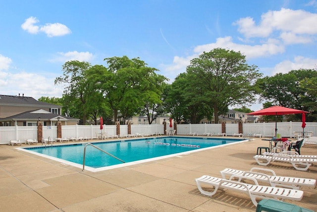 community pool featuring a patio and fence