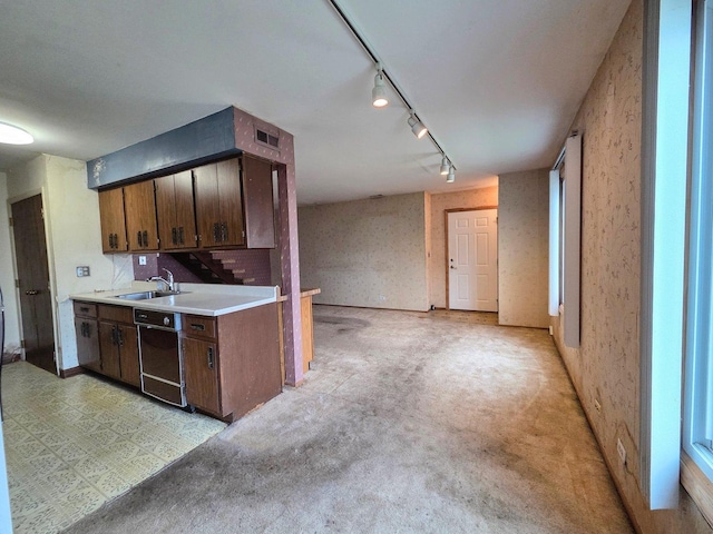 kitchen featuring a sink, light countertops, rail lighting, black dishwasher, and visible vents