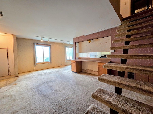 stairway featuring track lighting, carpet flooring, and visible vents