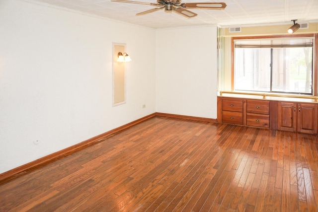unfurnished room featuring visible vents, a ceiling fan, baseboards, and dark wood-style floors
