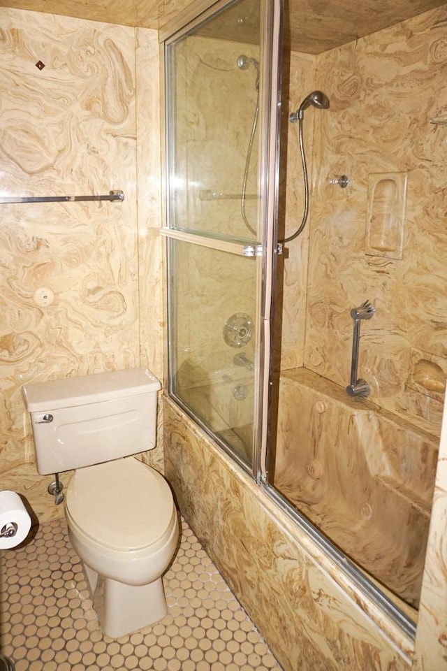 bathroom featuring tile patterned flooring, enclosed tub / shower combo, and toilet