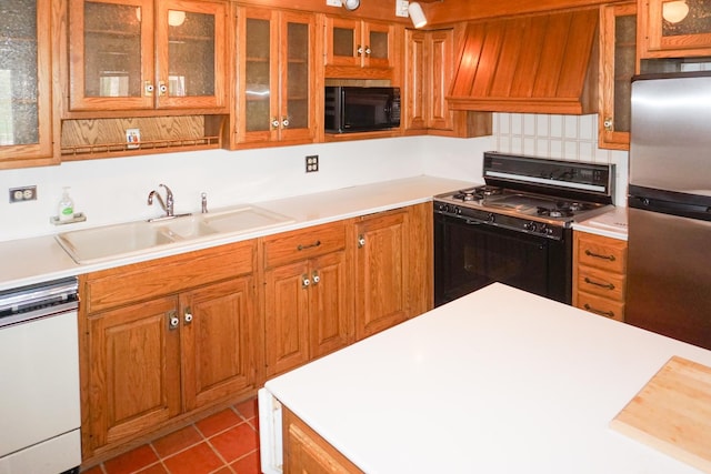 kitchen featuring light countertops, a sink, black appliances, and custom range hood