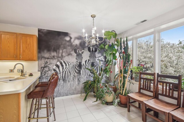 dining room featuring a chandelier, baseboards, and light tile patterned floors