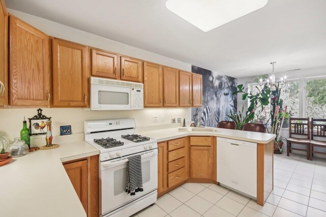 kitchen with white appliances, a peninsula, a sink, and light countertops