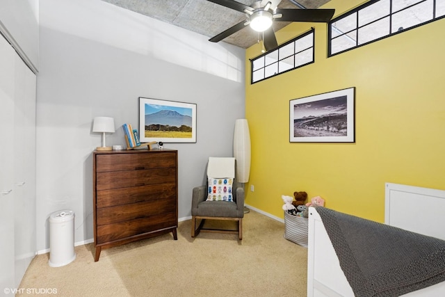 living area with carpet, ceiling fan, and baseboards