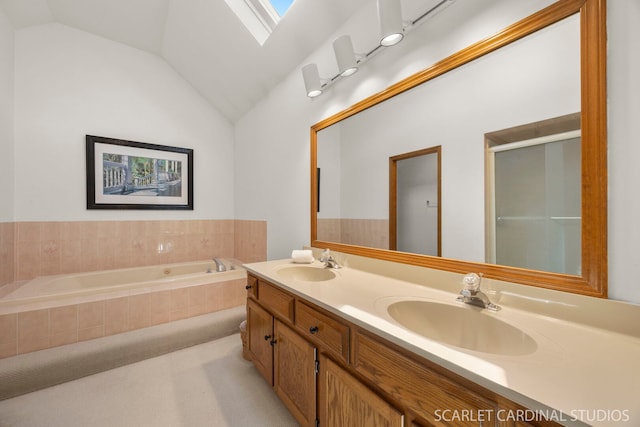 bathroom with a garden tub, a skylight, double vanity, vaulted ceiling, and a shower with shower door