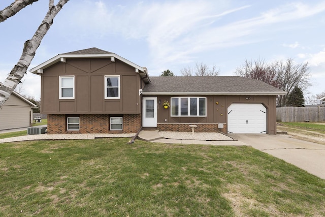 tri-level home with a garage, fence, board and batten siding, and concrete driveway