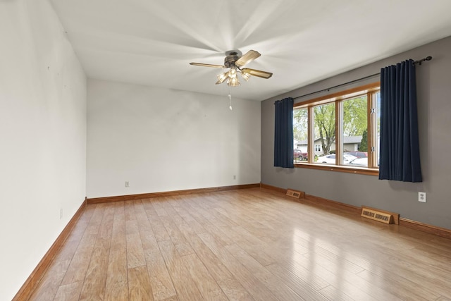 unfurnished room with a ceiling fan, visible vents, and wood finished floors