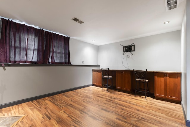 unfurnished office with visible vents, recessed lighting, light wood-style flooring, and baseboards