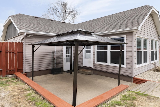 back of house with a patio, a gazebo, fence, and a shingled roof