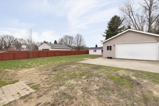 view of yard with fence, an outbuilding, and a garage