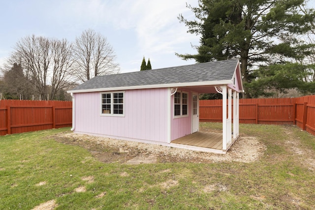 view of outdoor structure featuring a fenced backyard and an outbuilding