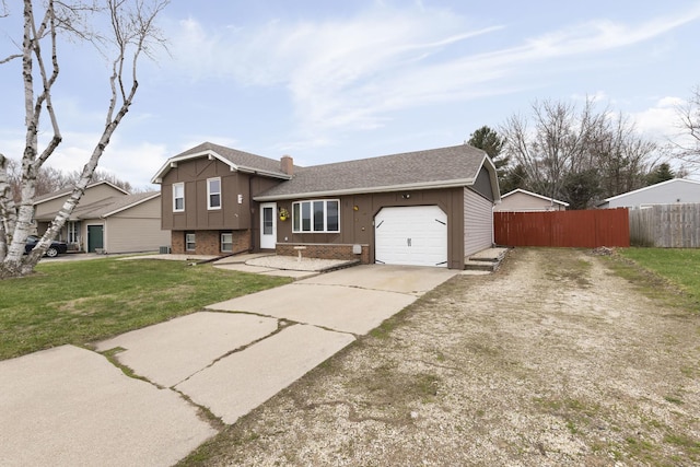 tri-level home with roof with shingles, brick siding, fence, concrete driveway, and an attached garage