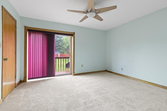 carpeted empty room featuring baseboards, ceiling fan, and visible vents