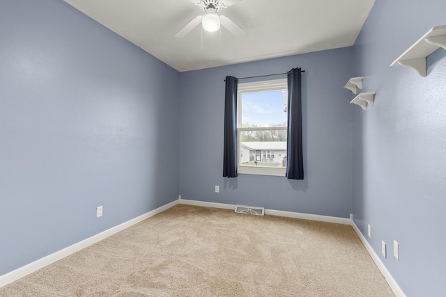 spare room with visible vents, carpet flooring, baseboards, and ceiling fan