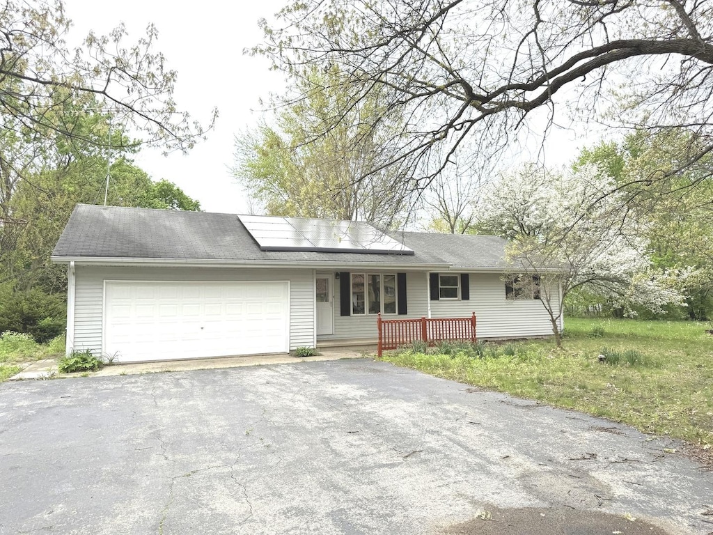 35828 Jay Dr, Custer Park, IL 60481 - view of front of house with an attached garage, a shingled roof, aphalt driveway, roof mounted solar panels, and covered porch