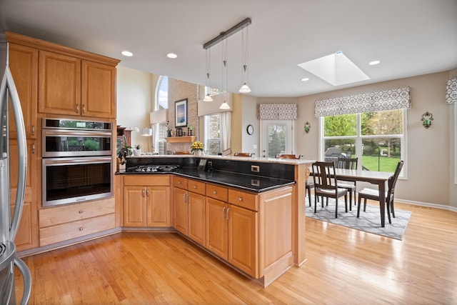 40W434 Triple Oaks Farm Dr, Hampshire, IL 60140 - kitchen with a peninsula, a skylight, light wood-style floors, stainless steel appliances, and pendant lighting