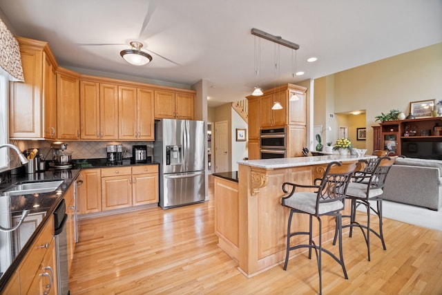 40W434 Triple Oaks Farm Dr, Hampshire, IL 60140 - kitchen with appliances with stainless steel finishes, a sink, light wood-type flooring, a kitchen bar, and tasteful backsplash