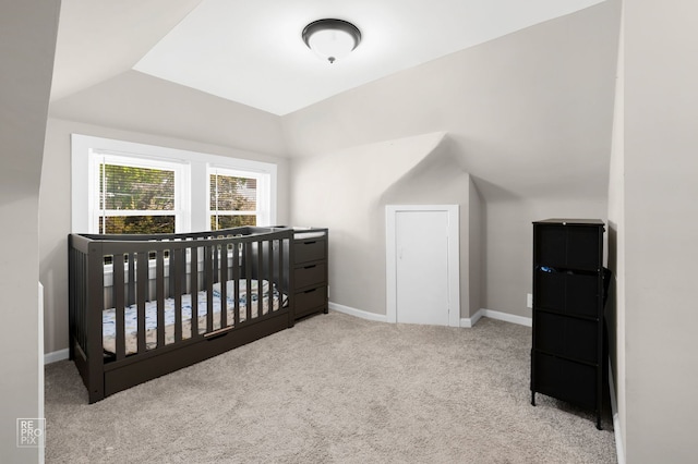 carpeted bedroom with vaulted ceiling and baseboards