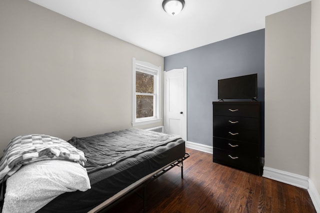bedroom featuring baseboards and dark wood-style flooring