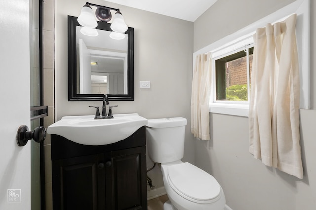 bathroom featuring baseboards, toilet, and vanity