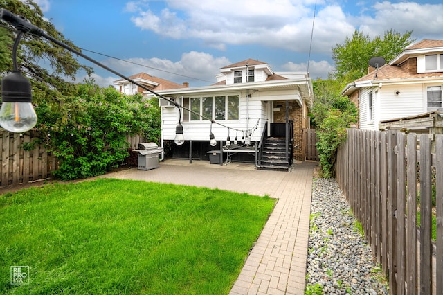 rear view of house with a patio area and a sunroom