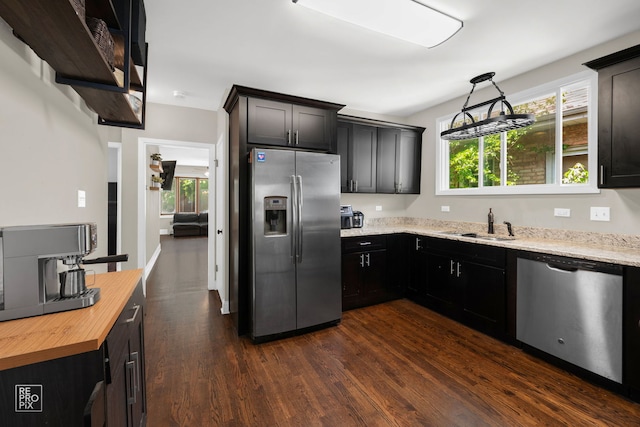 kitchen featuring appliances with stainless steel finishes, dark wood-style floors, wooden counters, a sink, and dark cabinetry