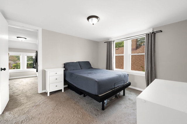 bedroom with light carpet and baseboards