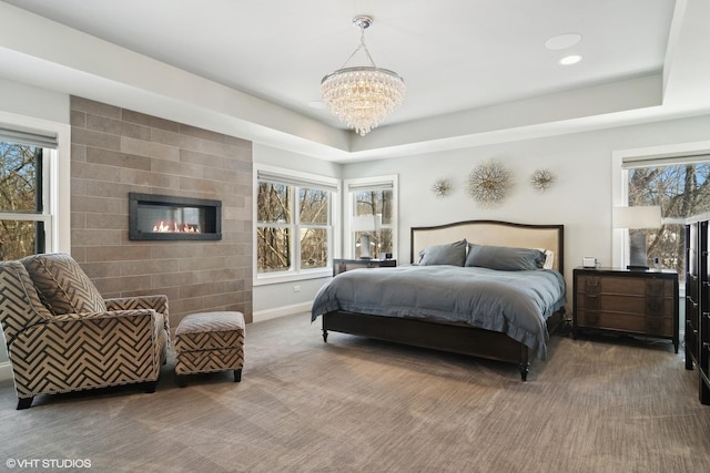 bedroom with carpet, a notable chandelier, multiple windows, and a large fireplace