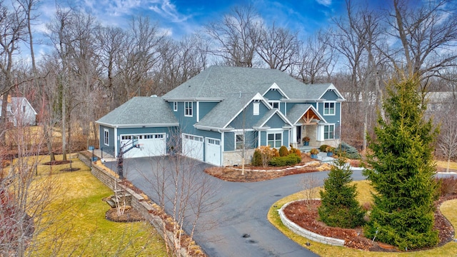 craftsman inspired home featuring fence, a shingled roof, a front lawn, a garage, and driveway