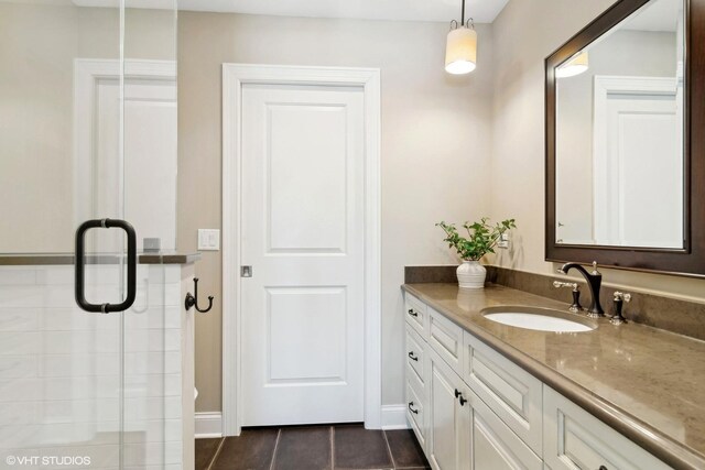 full bathroom with vanity, baseboards, a shower with door, and tile patterned flooring