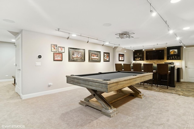 rec room featuring track lighting, light colored carpet, and indoor bar