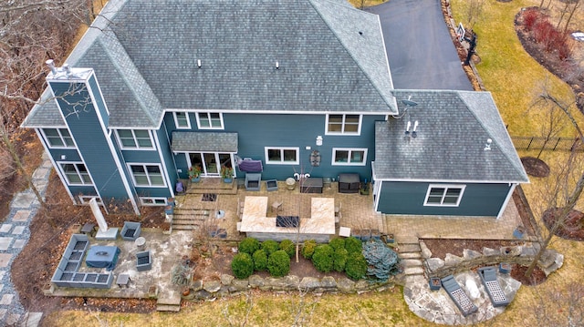 back of property with a patio, an outdoor hangout area, and roof with shingles
