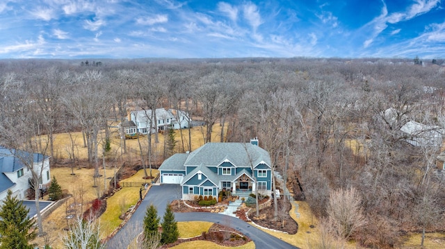 birds eye view of property featuring a wooded view