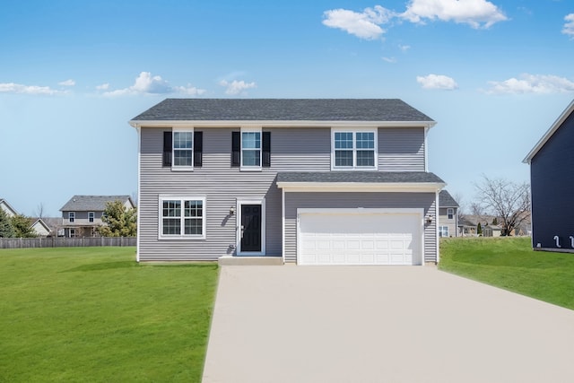 view of front facade with fence, an attached garage, concrete driveway, and a front yard