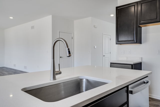kitchen featuring baseboards, dark wood-style floors, recessed lighting, light countertops, and a sink