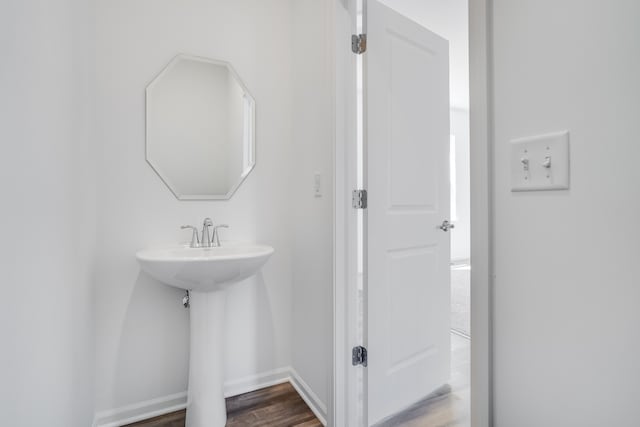 bathroom with baseboards and wood finished floors