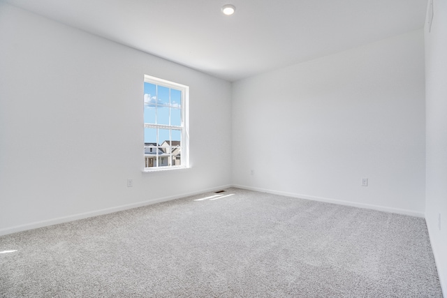 carpeted empty room featuring baseboards