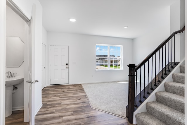 entrance foyer with baseboards, recessed lighting, wood finished floors, and stairway