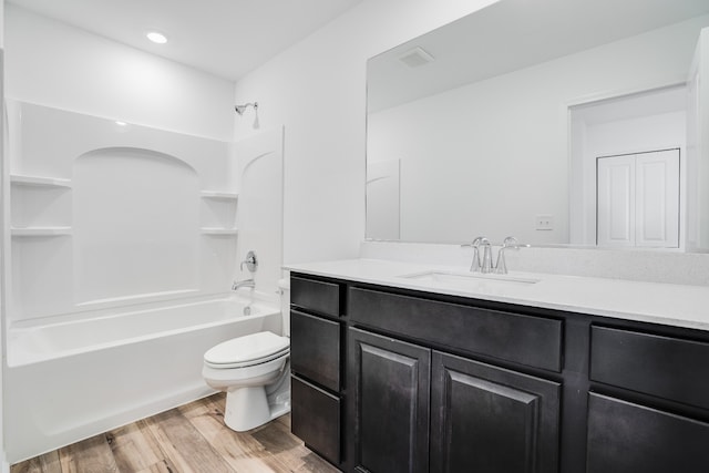 full bath with toilet, washtub / shower combination, wood finished floors, and vanity