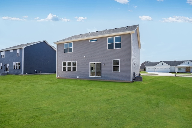 back of house featuring a lawn, a garage, and central air condition unit